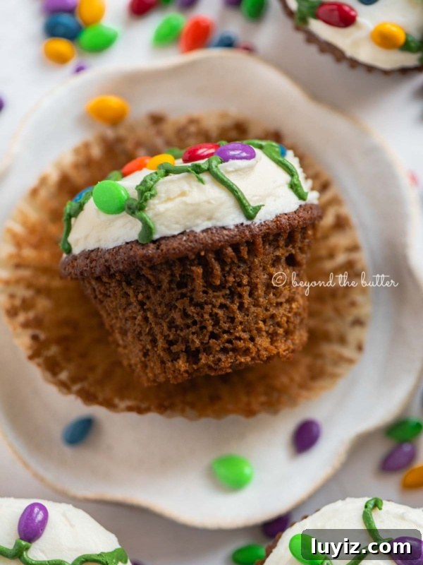 Holiday Jamboree Cookie Recipes for Festive Baking 5 Liner removed gingerbread cupcake on a small dessert plate on a white, chocolate covered sunflower seed background.