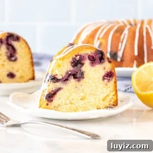 Lemon Blueberry Bundt Cake Recipe with Zesty Glaze 5 Slice of lemon blueberry bundt cake with fork
