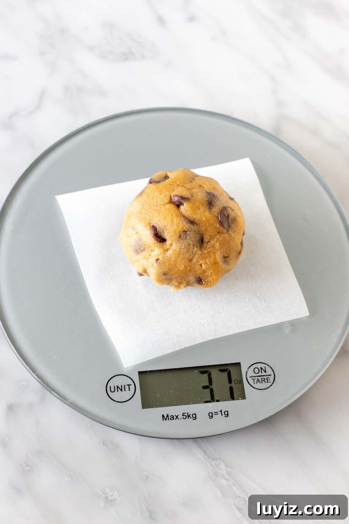 Bakery-Style Chocolate Chip Cookies: Soft, Chewy, and Irresistible 4 Cookie dough ball on a baking scale.