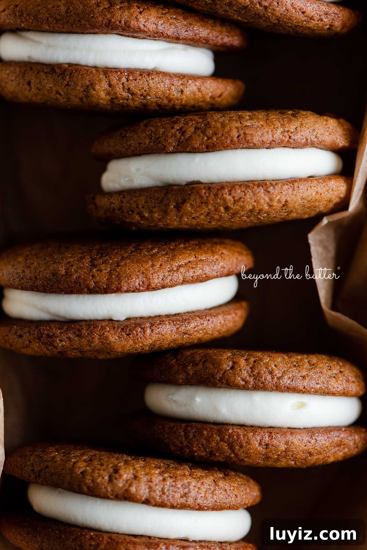 Gingerbread Whoopie Pies Recipe: Soft Molasses Sandwich Cookies 6 Gingerbread whoopie pies in a natural parchment paper lined ceramic pan | © Beyond the Butter®