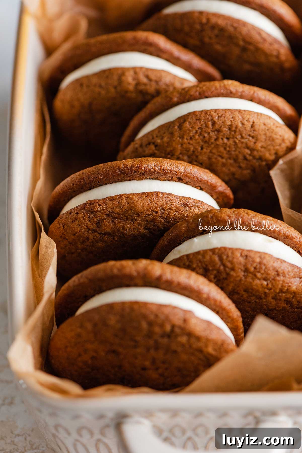 Gingerbread Whoopie Pies Recipe: Soft Molasses Sandwich Cookies 7 Natural parchment paper lined ceramic baking pan with homemade gingerbread whoopie pies | © Beyond the Butter®