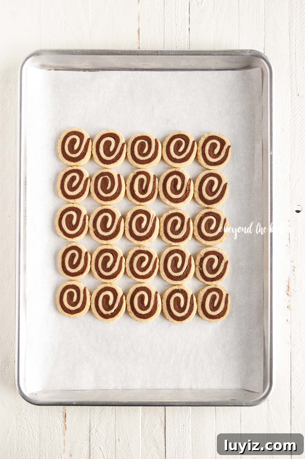 Chocolate Pinwheel Cookies: Soft Swirl Cookie Recipe for Parties 6 Overhead image of Chocolate Pinwheel Cookies in rows on a baking sheet | All images © Beyond the Butter™