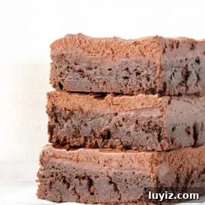 Decadent Fudge Brownies Topped with Rich Chocolate Frosting 11 Stack of three brownies with chocolate frosting