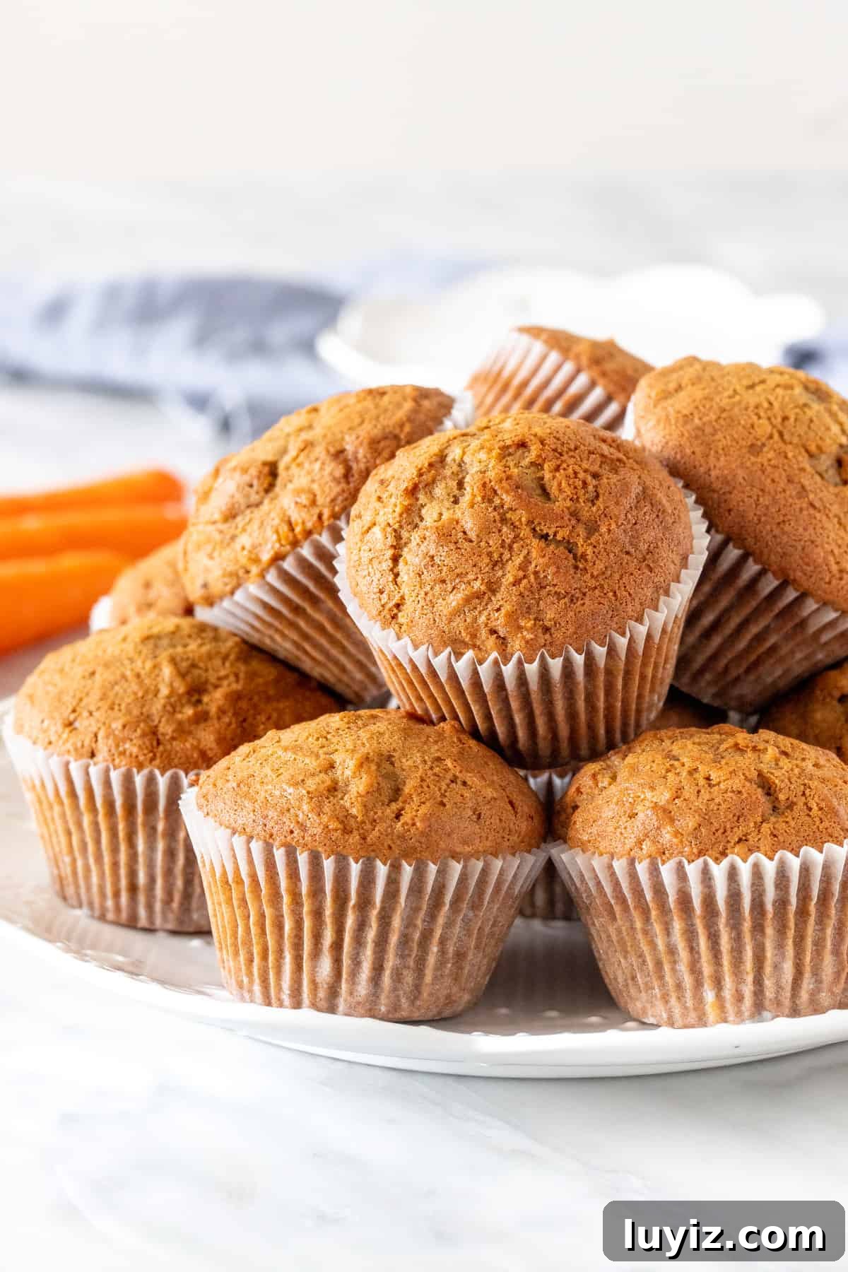 Moist Carrot Cake Muffins with Cream Cheese Frosting 3 Plate of carrot muffins