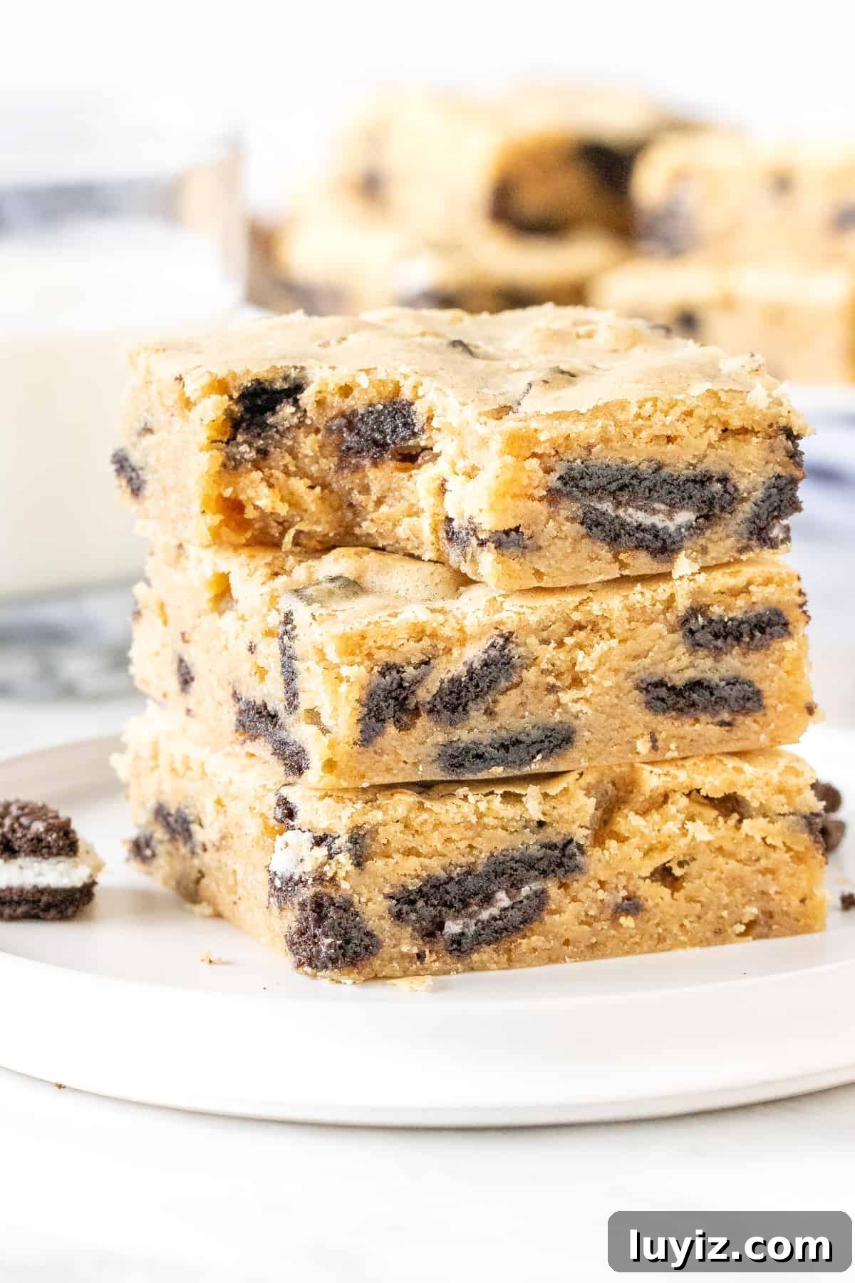 Oreo Blondie Recipe: Chewy, Creamy Cookies-and-Cream Bars 6 Stack of Oreo blondies on a plate with a glass of milk