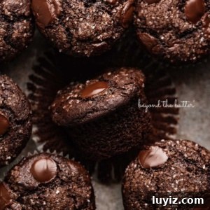 Ultimate Double Chocolate Muffins Recipe – Moist & Fudgy 9 Double chocolate muffins in a vintage baking tin with one unwrapped.