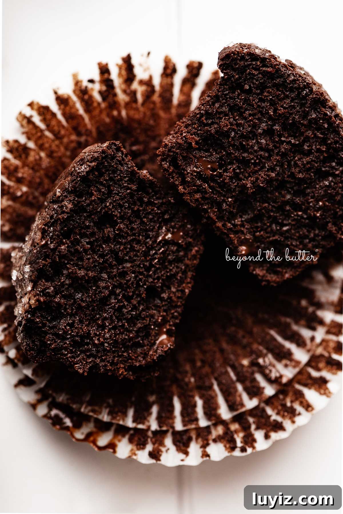 Ultimate Double Chocolate Muffins Recipe – Moist & Fudgy 4 Double chocolate muffin cut in half on opened muffin liners | © Beyond the Butter®