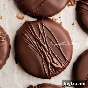 Homemade Thin Mints Recipe: Crisp Chocolate Mint Cookies 18 Chocolate dipped thin mints on a wax paper lined baking sheet.
