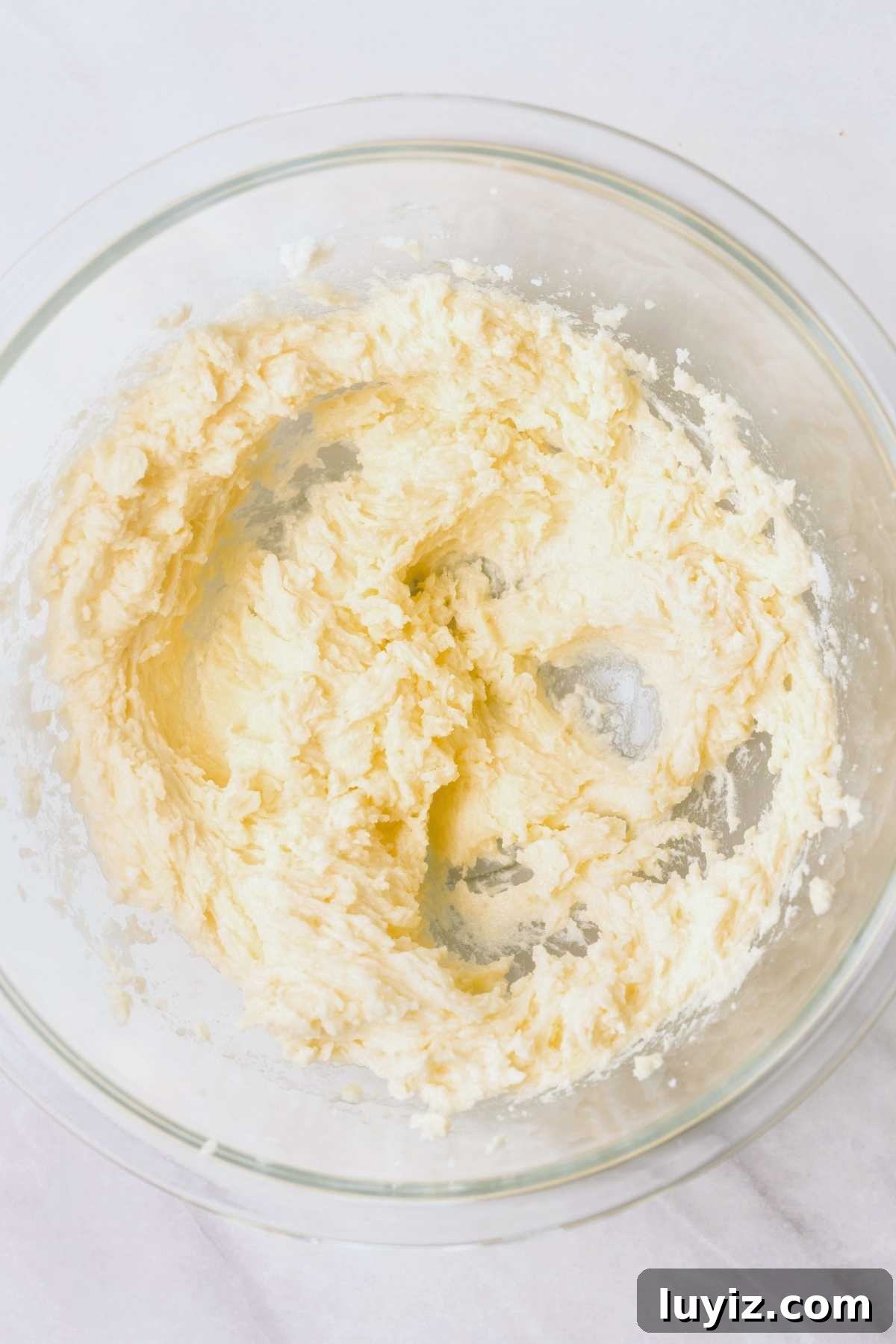Homemade Thin Mints Recipe: Crisp Chocolate Mint Cookies 6 Unsalted butter, granulated sugar, egg, and extracts blended together in a large glass mixing bowl on a white marbled background.