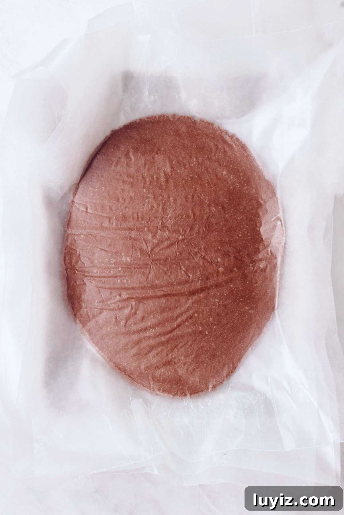 Homemade Thin Mints Recipe: Crisp Chocolate Mint Cookies 8 Rolled out thin mint cookie dough between two layers of wax paper on a white marbled background.