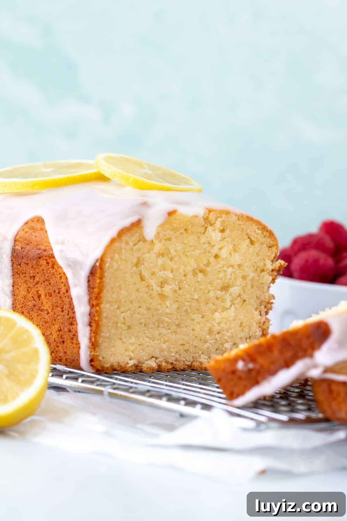 Lemon loaf with lemon glaze, on a cooling rack with slices cut