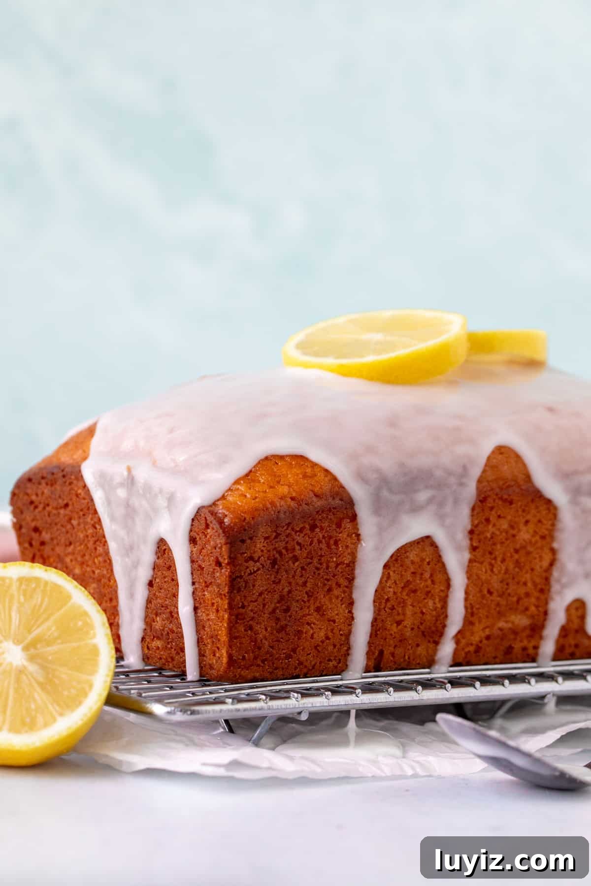 Super Moist Lemon Loaf with Bright Glaze 3 Lemon loaf with lemon glaze on a cooling rack