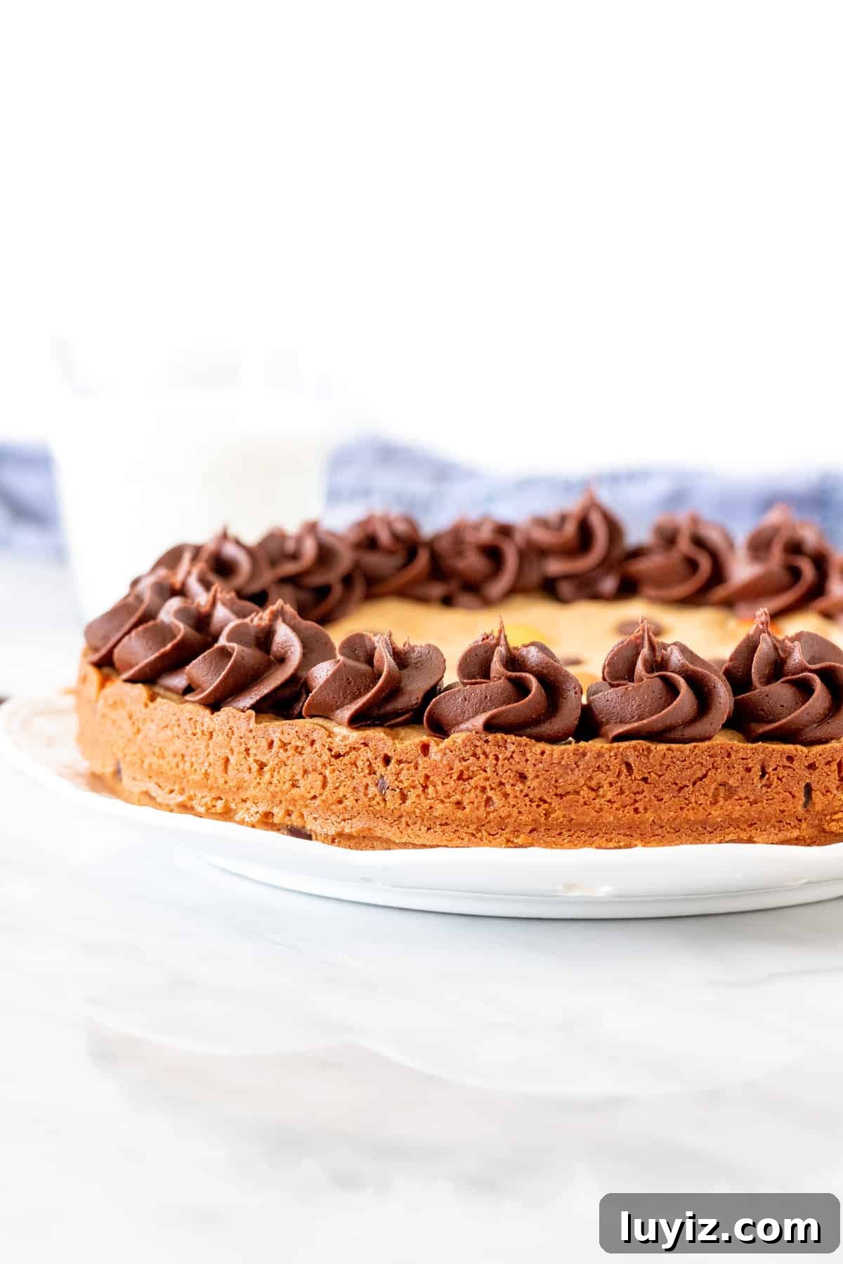 Peanut Butter Cookie Cake Recipe — Moist, Chewy & Decadent 3 9-inch round cookie cake with icing around the edges.