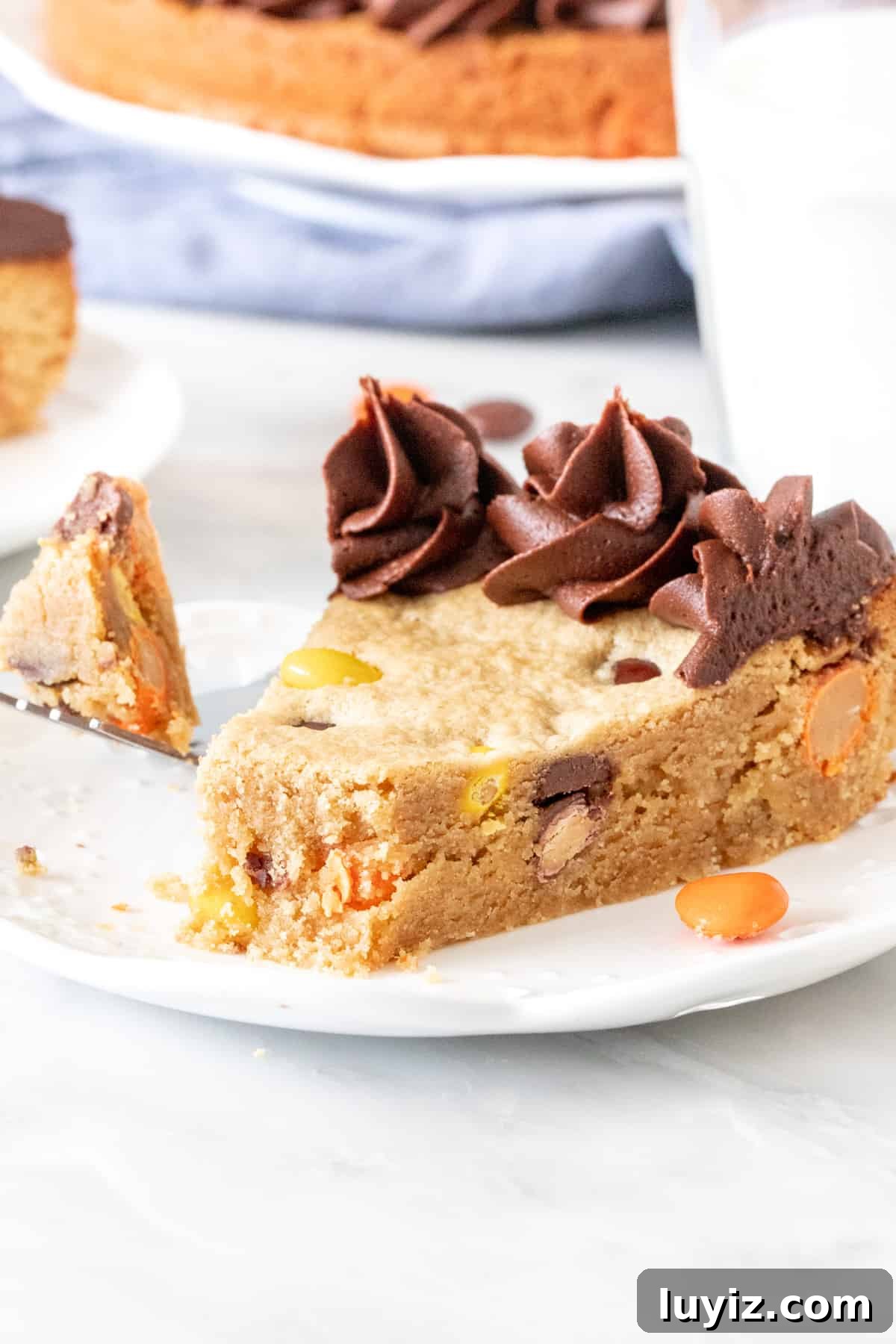 Peanut Butter Cookie Cake Recipe — Moist, Chewy & Decadent 4 Piece of peanut butter cookie cake with a bite taken out of it.
