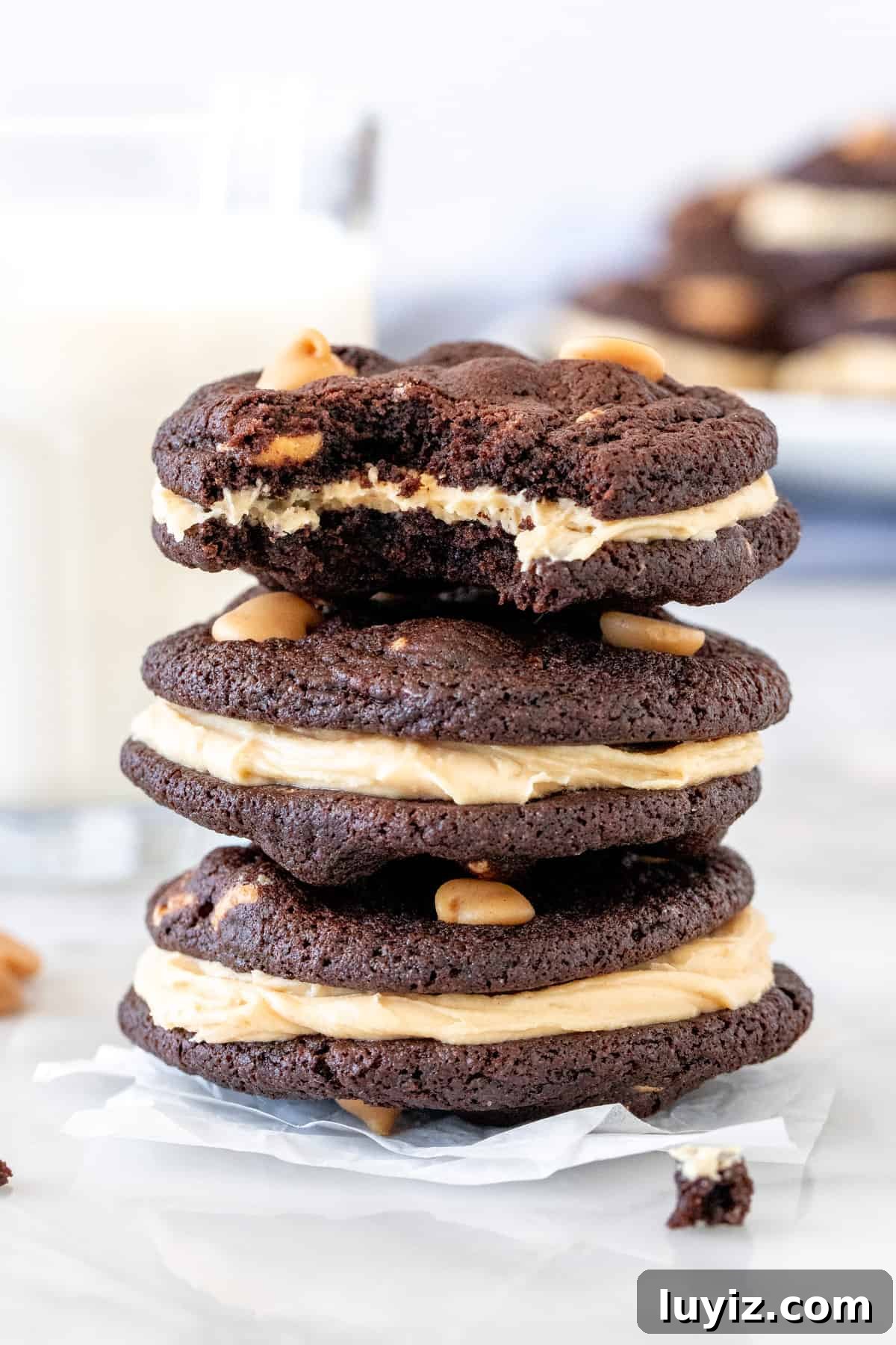 Chocolate Peanut Butter Sandwich Cookies Recipe — Homemade Treats 4 Stack of 3 chocolate peanut butter sandwich cookies with a glass of milk