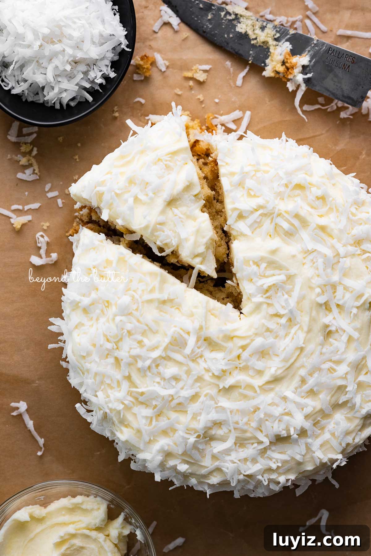 Moist Single-Layer Coconut Cake Recipe for Any Occasion 2 Single layer coconut cake frosted with coconut buttercream with slice cut out on natural parchment paper background | © Beyond the Butter®
