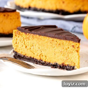 Pumpkin Chocolate Cheesecake Recipe: Decadent Fall Dessert 5 Slice of chocolate pumpkin cheesecake with full cheesecake in the background