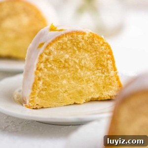 Moist Lemon Cream Cheese Pound Cake Recipe 13 Small lemon cream cheese pound cake slice on a small dessert plate on white background.
