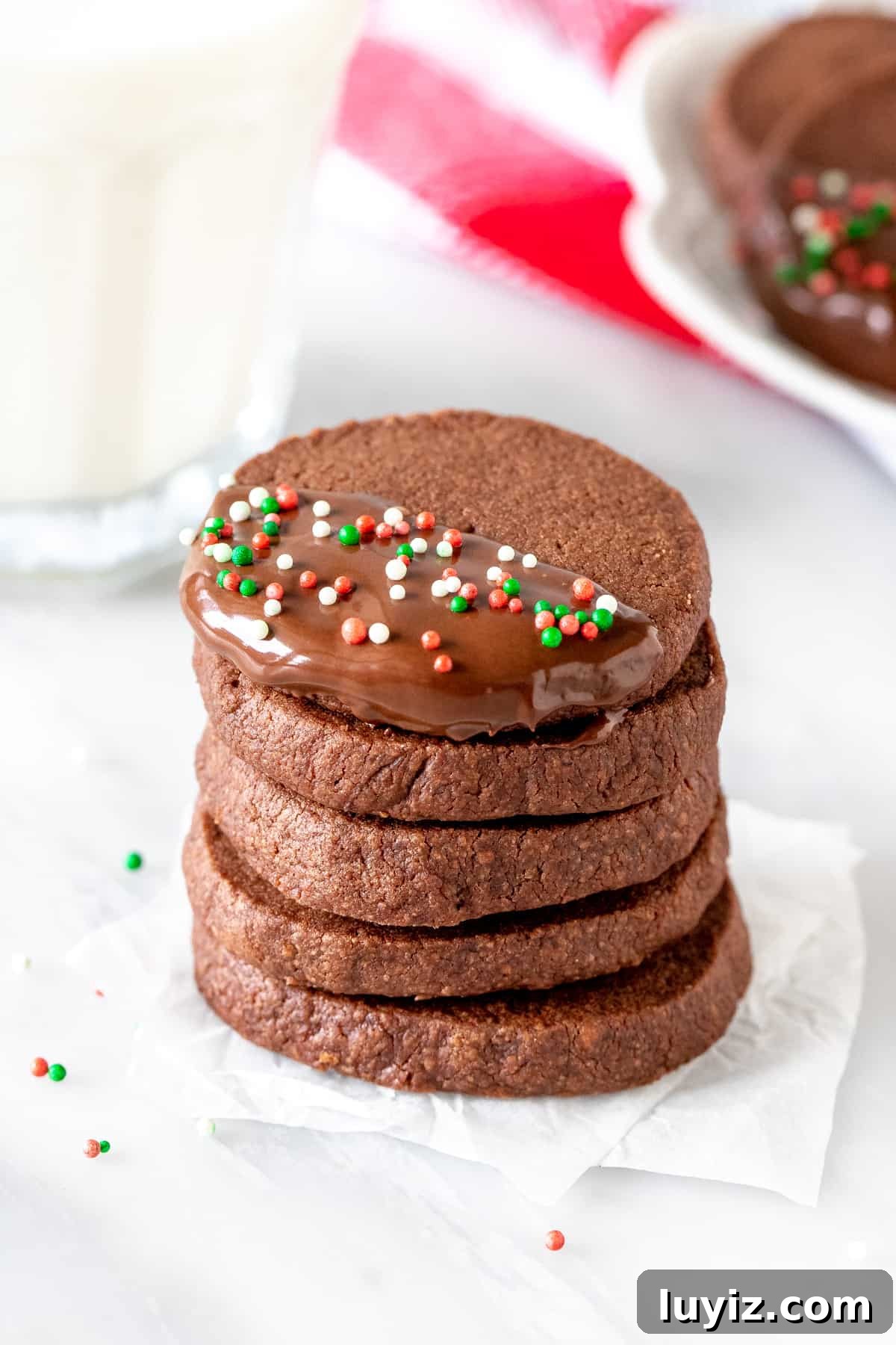 Buttery Chocolate Shortbread Cookies — Decadent, Melt-in-Your-Mouth 5 Stack of Christmas chocolate shortbread with glass of milk.