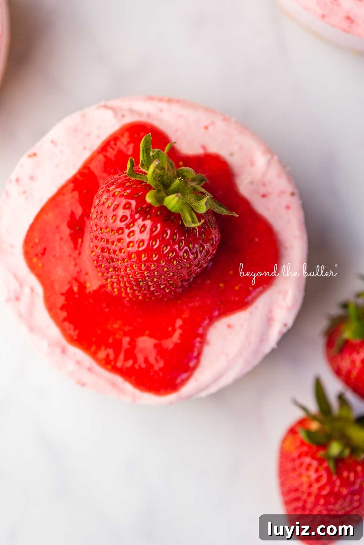 Mini No-Bake Strawberry Cheesecakes (Individual Cups) 8 Sliced small 4-inch no-bake strawberry cheesecake on a marbled background | © Beyond the Butter®