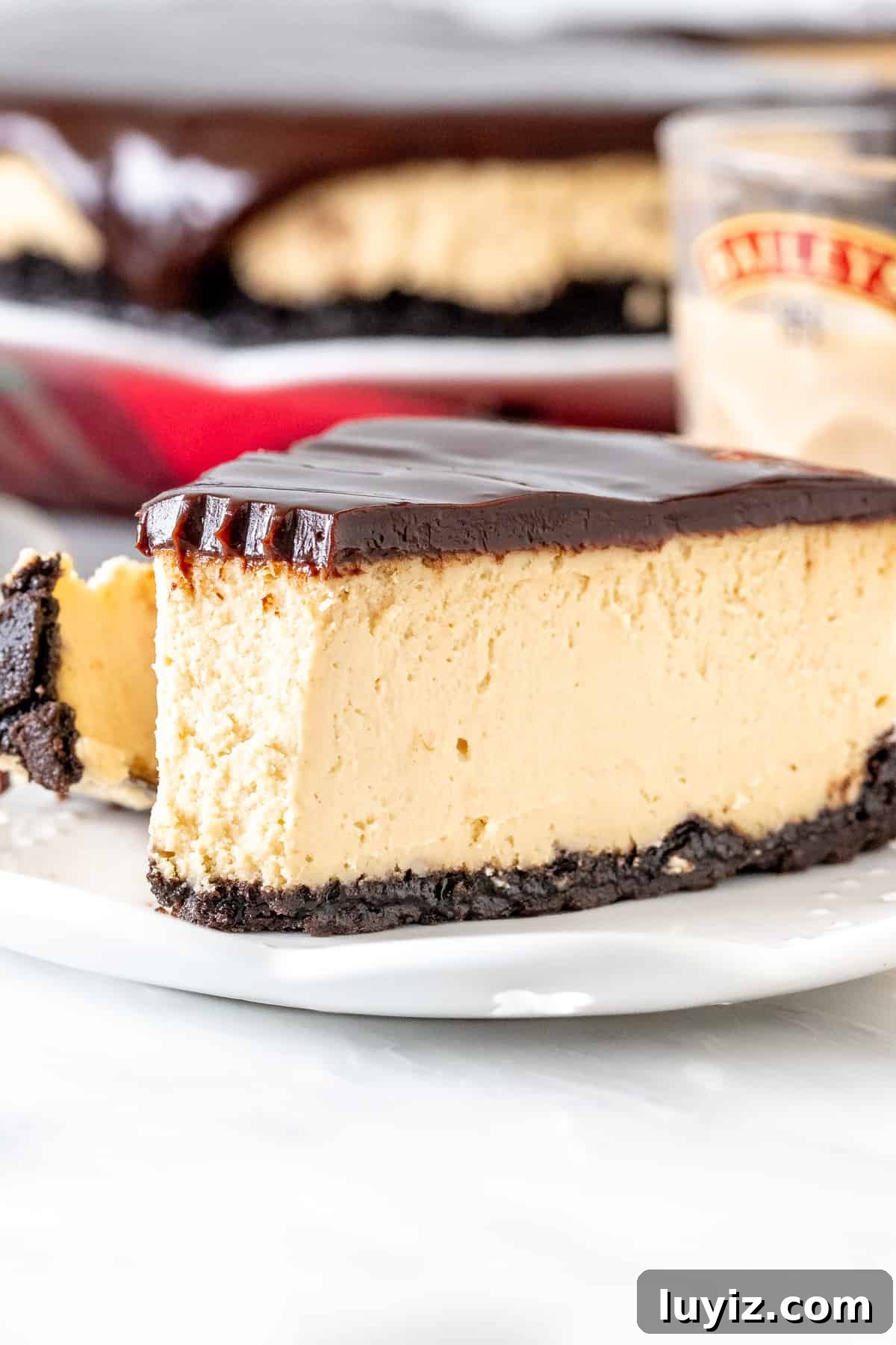 Baileys Cheesecake Recipe: Decadent Irish Cream Dessert 4 Slice of Baileys cheesecake with Oreo crust and chocolate ganache