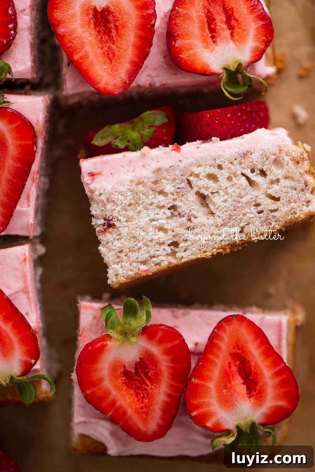 Mini Strawberry Sheet Cake Recipe: Quick Moist Fresh Strawberry Cake 2 Slices of mini strawberry sheet cake topped with strawberry buttercream frosting and fresh strawberries with one slice on its side.