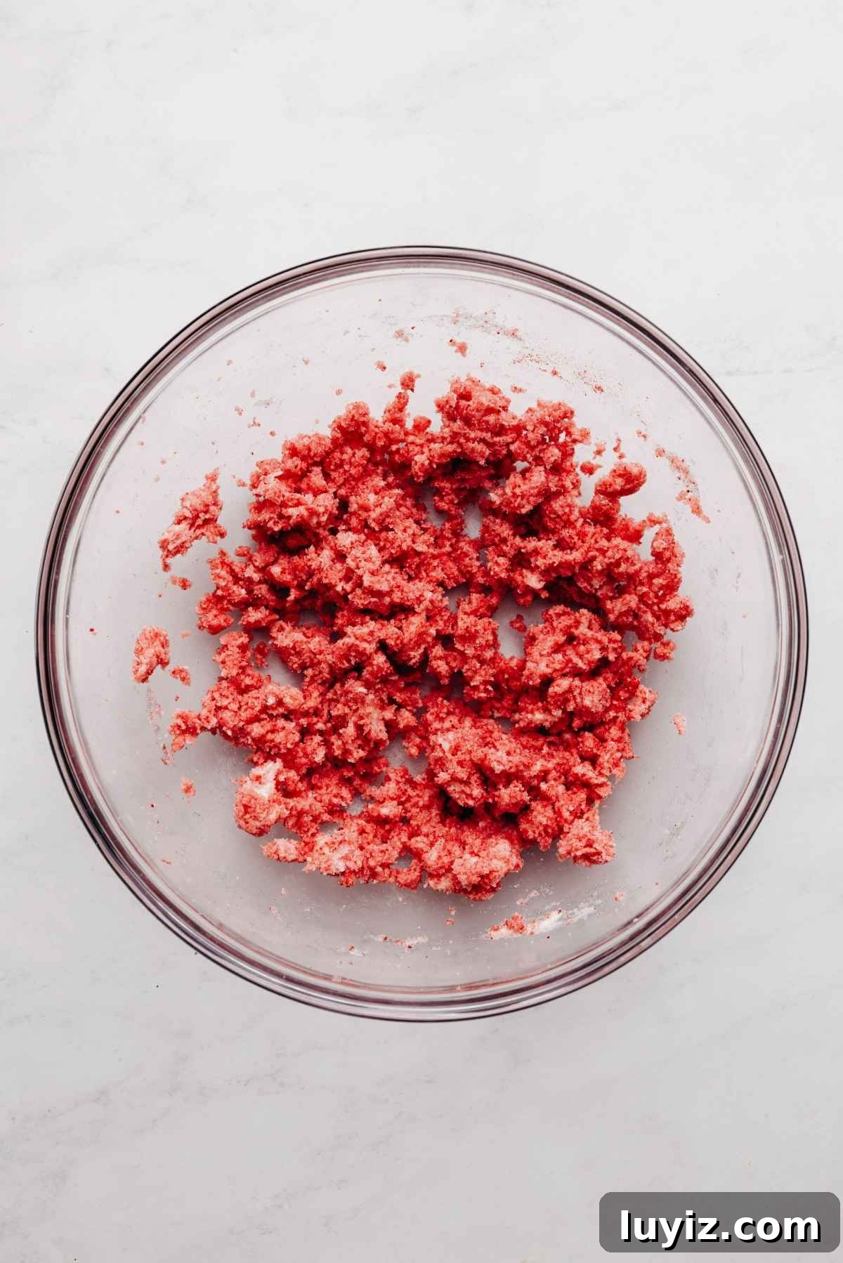 Mini Strawberry Sheet Cake Recipe: Quick Moist Fresh Strawberry Cake 11 Freeze dried strawberry powder, butter, and sugar blended together in a glass mixing bowl on a white and grey textured background.