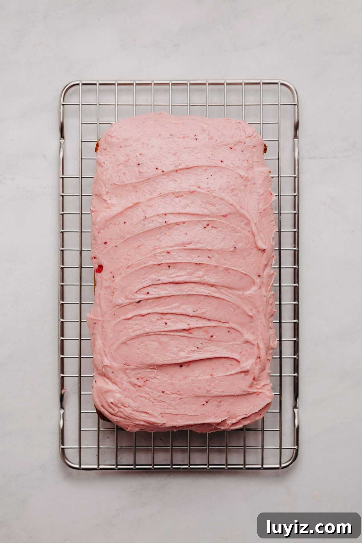 Mini Strawberry Sheet Cake Recipe: Quick Moist Fresh Strawberry Cake 19 Mini strawberry sheet cake frosted with strawberry buttercream frosting on a cooling rack.