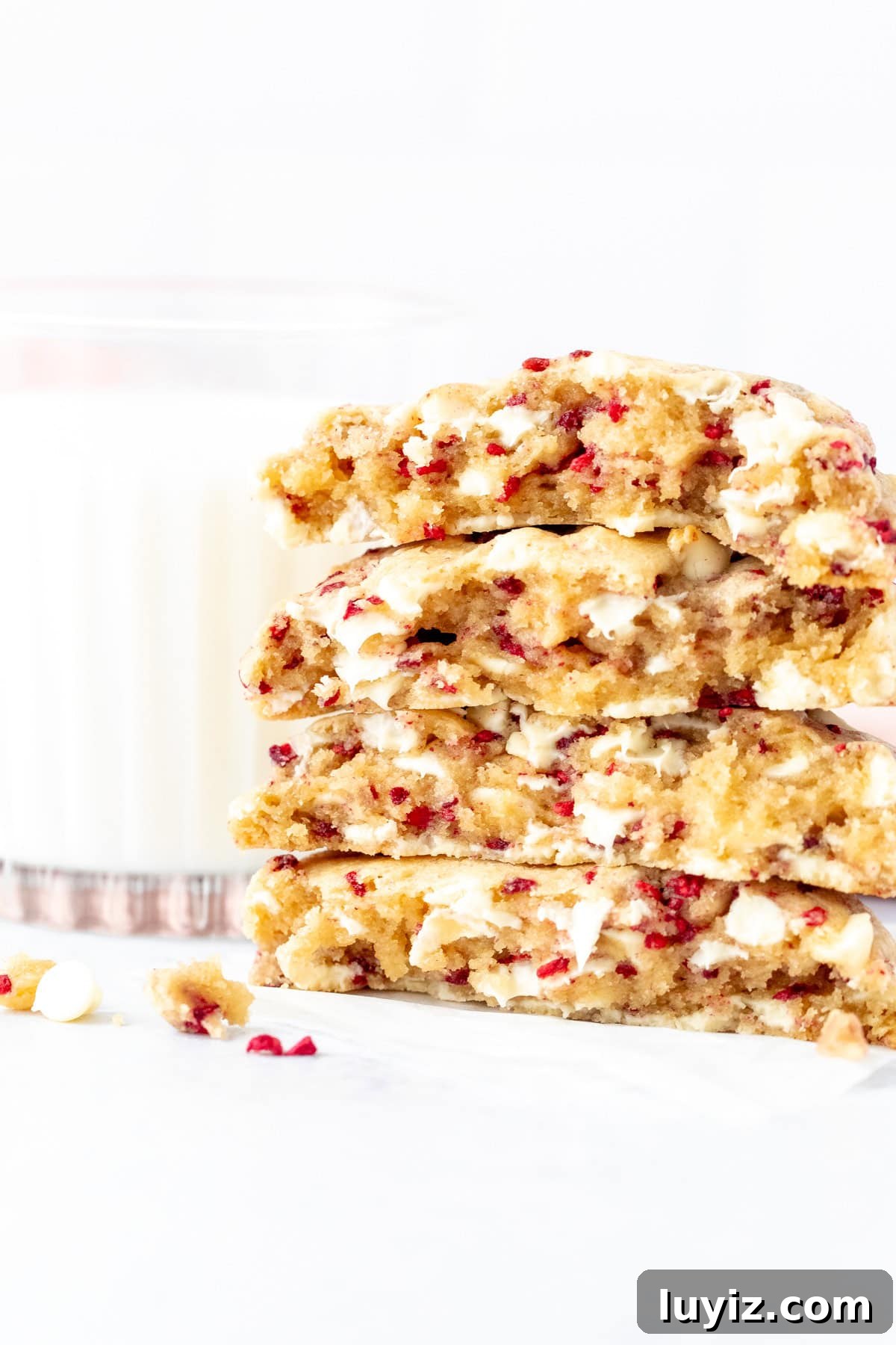 White Chocolate Raspberry Cookie Recipe (Soft & Irresistible) 6 Stack of white chocolate raspberry cookie halves with a glass of milk