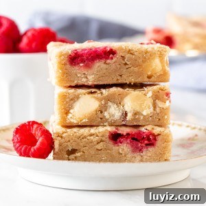 White Chocolate Raspberry Blondies Recipe with Gooey Berries 5 White chocolate raspberry blondies, stacked one on top of each other