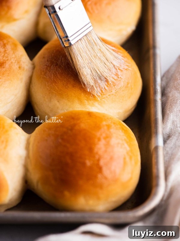 Homemade Applesauce Without Added Sugar: Simple Recipe 13 Small tray of honey butter dinner rolls being brushed with more honey butter.