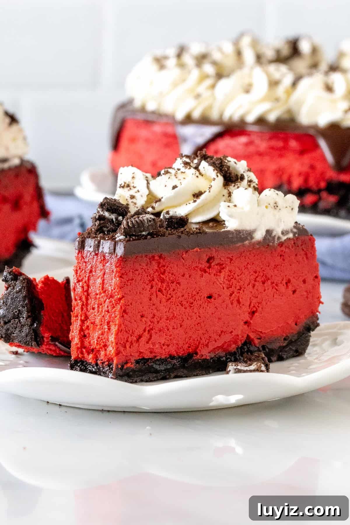 Red Velvet Oreo Cheesecake Recipe with Creamy Chocolate Swirls 5 Slice of red velvet Oreo cheesecake with a bite taken out