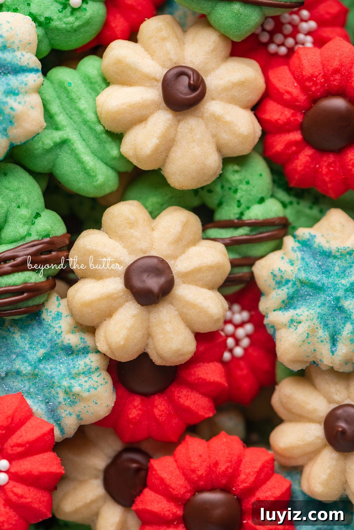 Crisp Butter Spritz Cookies: Traditional Holiday Recipe 2 Pile of decorated buttery classic spritz cookies | © Beyond the Butter®