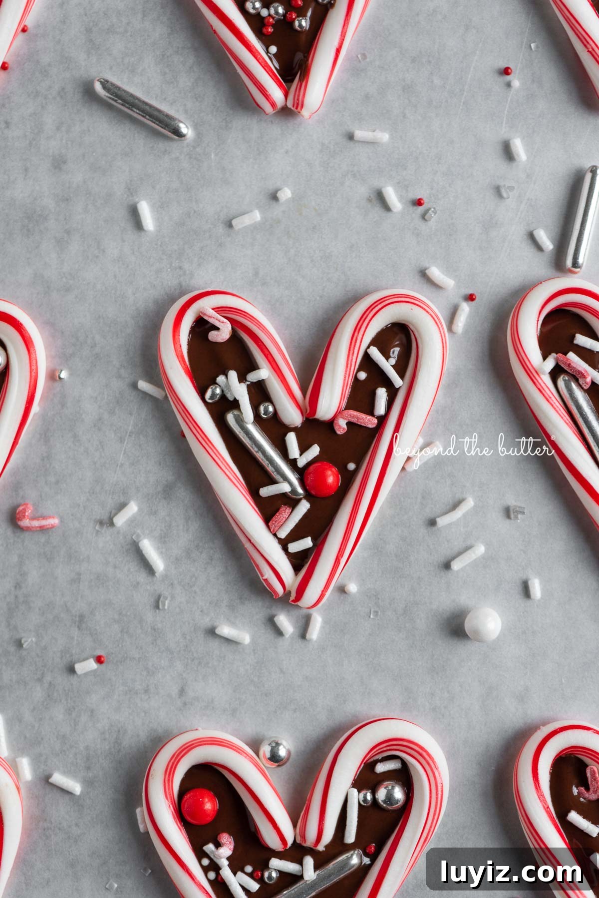 Candy Cane Heart Cookies: Festive Holiday Treats & Gift Ideas 2 Fun candy cane hearts on parchment paper | © Beyond the Butter®