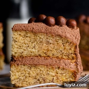 Ultra-Moist Banana Cake Recipe with Cream Cheese Frosting 10 Slice of 2 layer moist banana cake on ceramic dessert plates on a dark wood background.