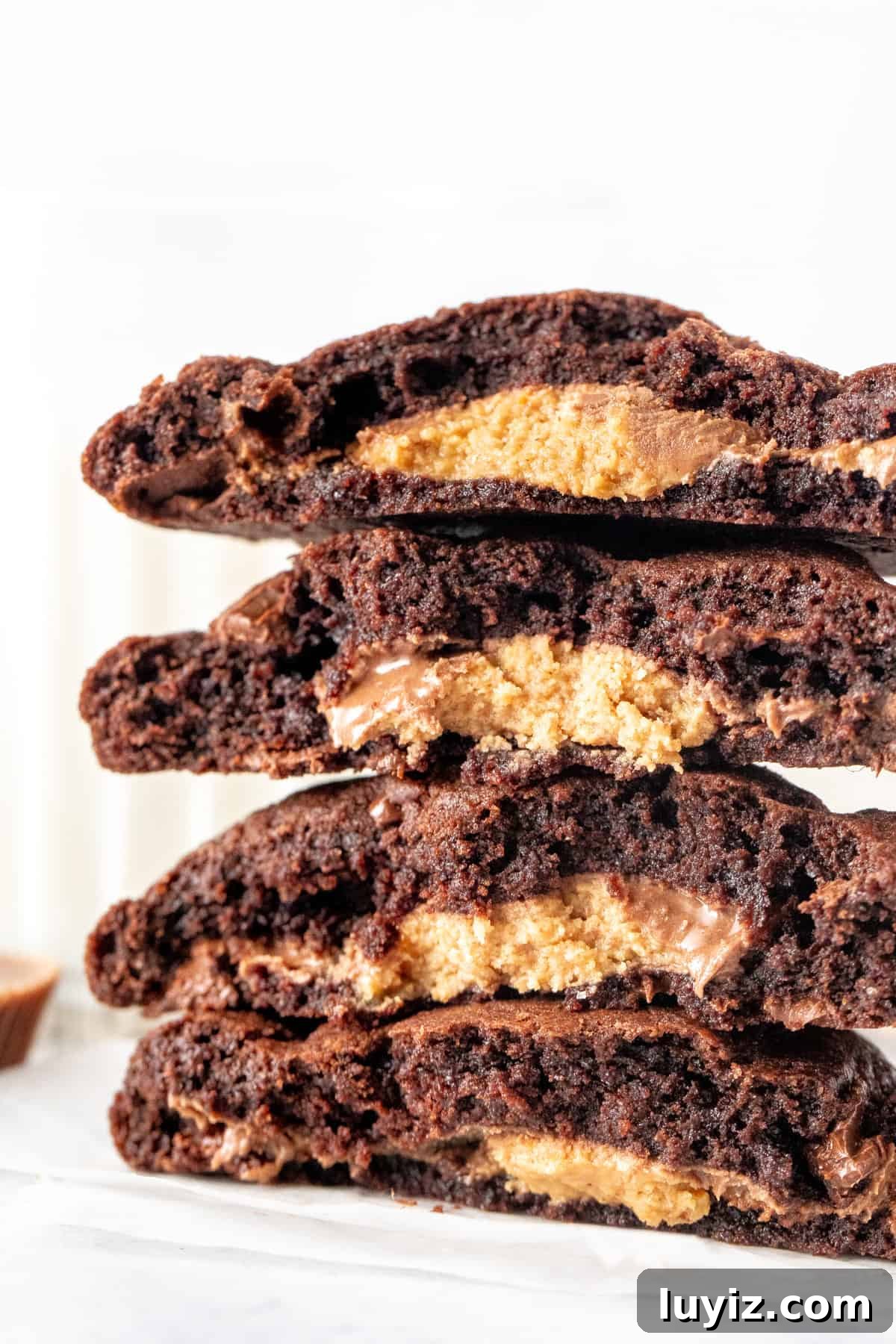 Reese’s Double Chocolate Cookie Recipe 6 Stack of chocolate cookies stuffed with a peanut butter cup, broken in half