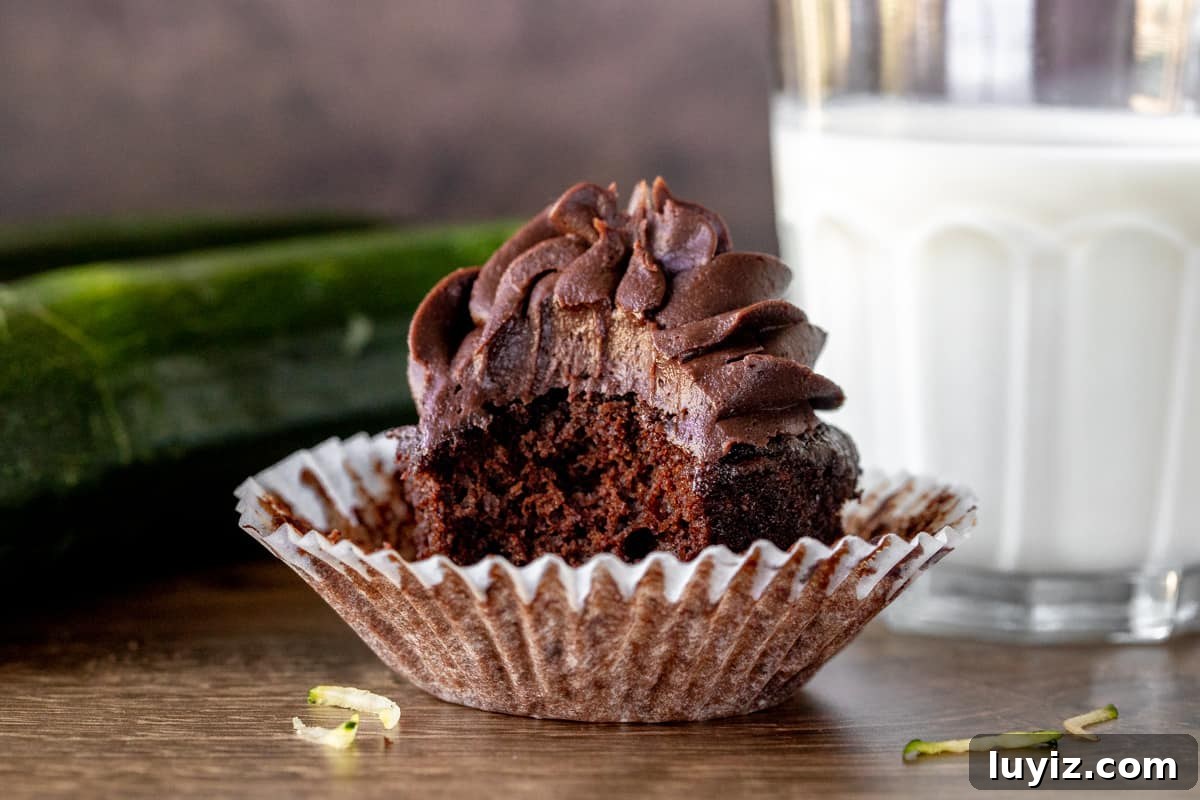 Decadent Chocolate Zucchini Cupcakes with Moist Fudgy Texture 6 Chocolate cupcake with a bite taken out with glass of milk