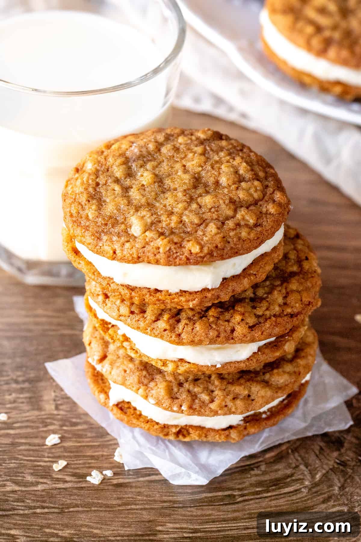 Homemade Oatmeal Cream Pies Recipe — Soft Chewy Oat Cookies Filled With Vanilla Cream 2 Stack of three oatmeal cream pies with glass of milk