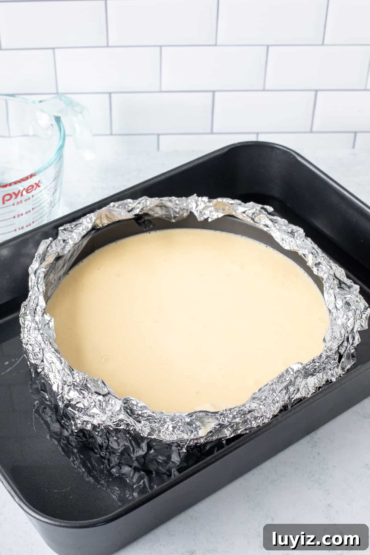 Unbaked cheesecake in a water bath