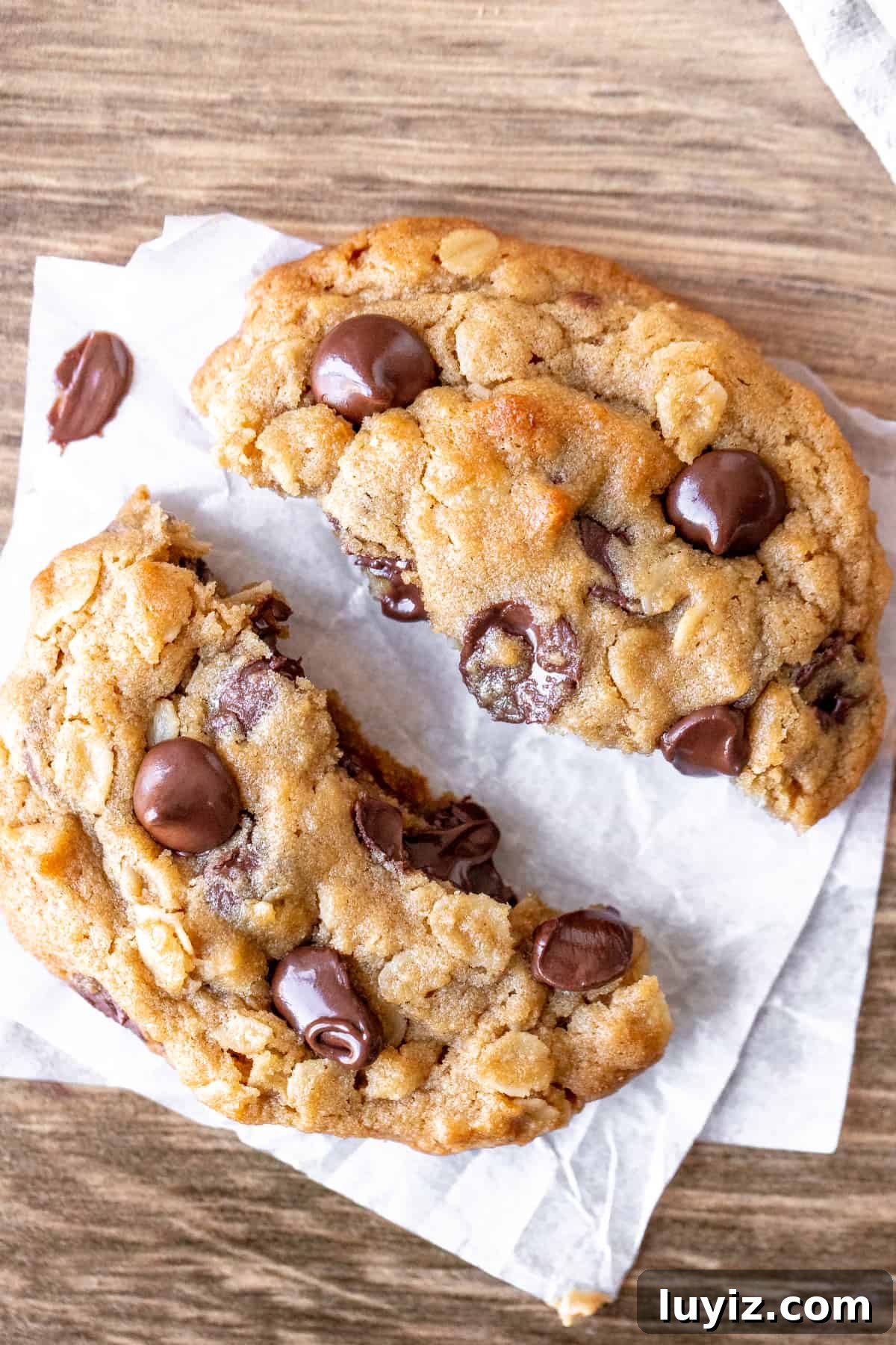 Peanut Butter Oatmeal Chocolate Chip Cookies Recipe You’ll Love 4 Peanut butter oatmeal cookie broken in half on baking paper