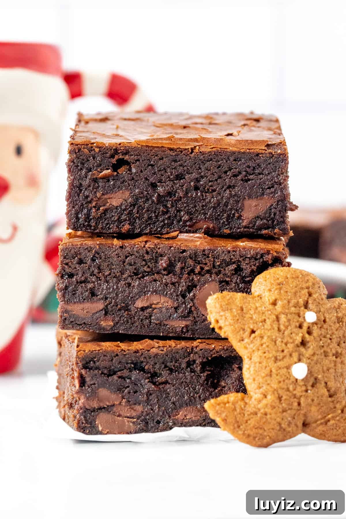 Gingerbread Brownies Recipe: Fudgy Spiced Chocolate Treat 2 Stack of 3 gingerbread brownies with gingerbread man cookie