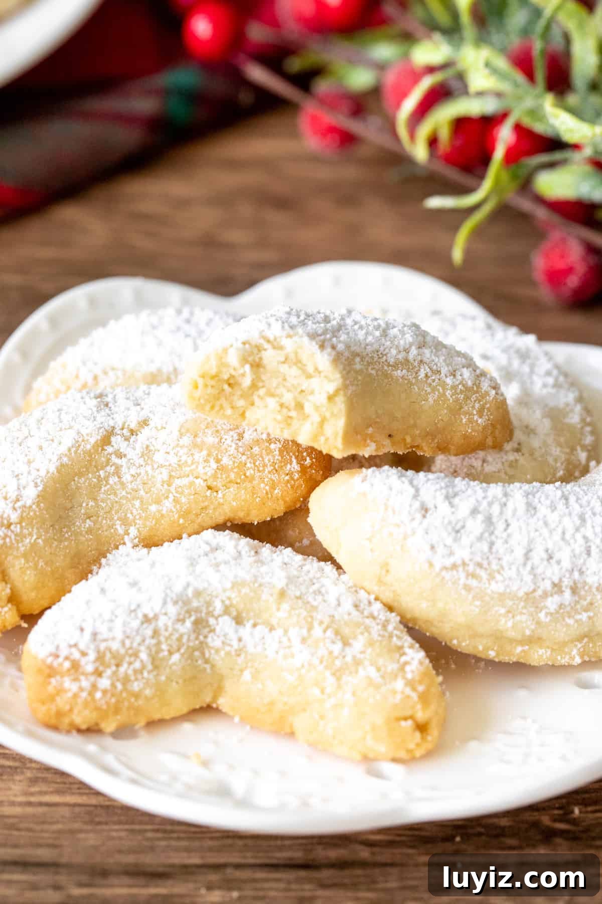 Buttery Almond Crescent Cookies: Classic Crescent Cookie Recipe 6 Plate of almond crescent cookies, with one cookie broken in half
