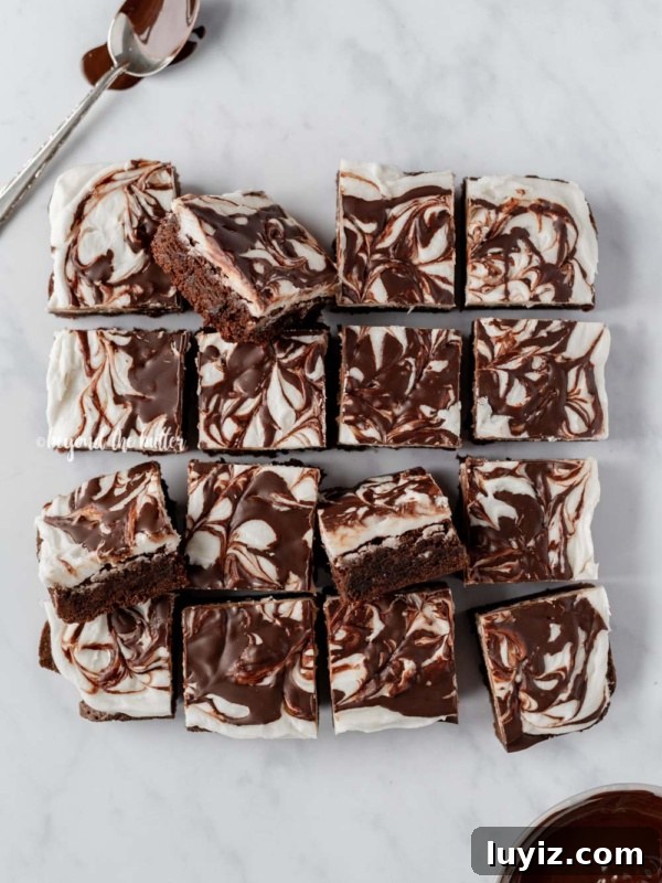 How to Make Classic Homemade Peppermint Patties at Home 13 Cut Chocolate Peppermint Swirled Brownies with chocolate covered spoon and bowl of melted chocolate on white marbled background.