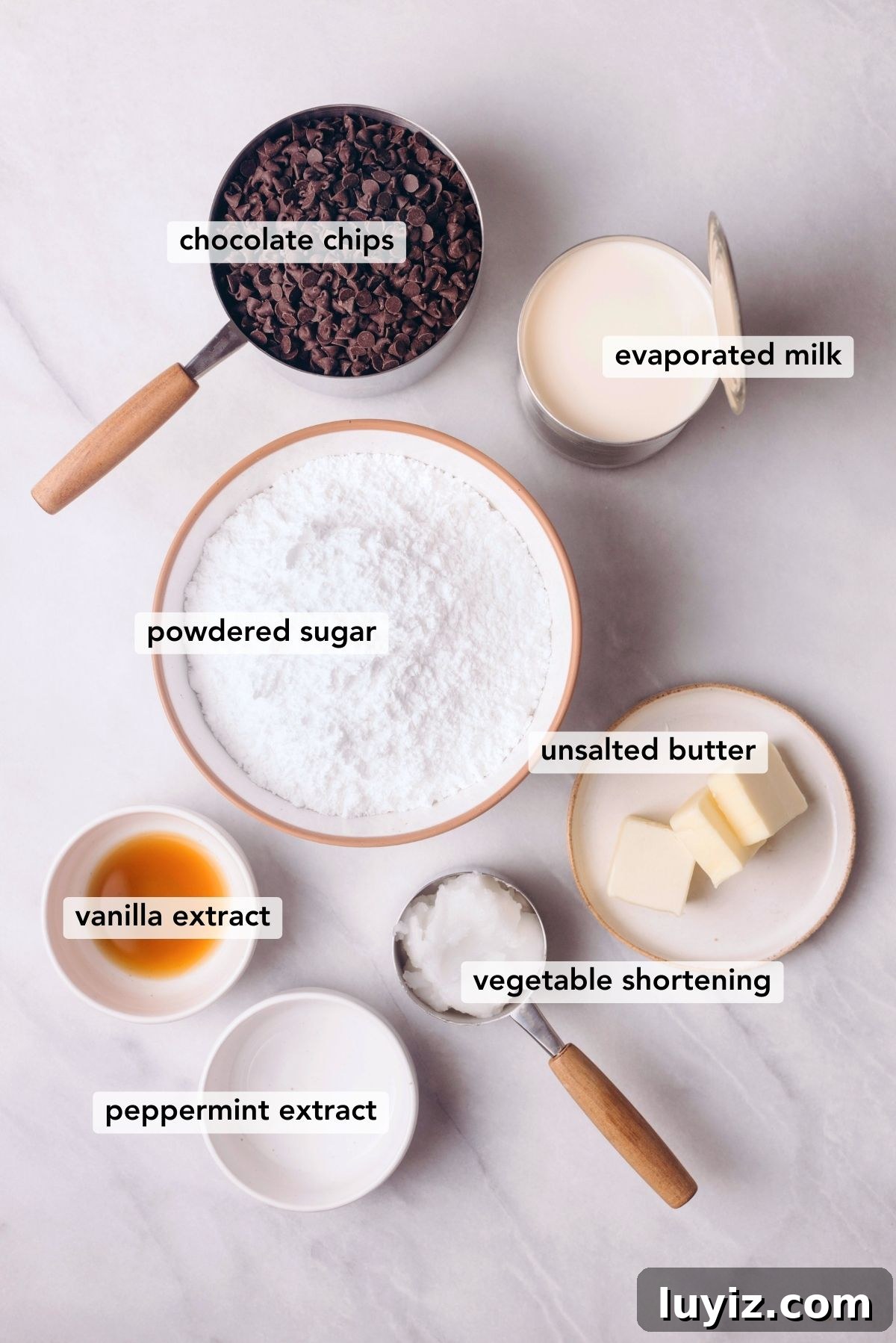 How to Make Classic Homemade Peppermint Patties at Home 3 Ingredients needed to make homemade peppermint patties on white marbled background.