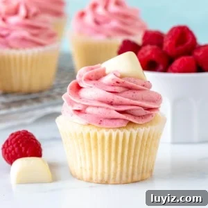 White Chocolate Raspberry Cupcakes Recipe for Decadent Treats 5 White chocolate cupcake with raspberry frosting with square of white chocolate on top
