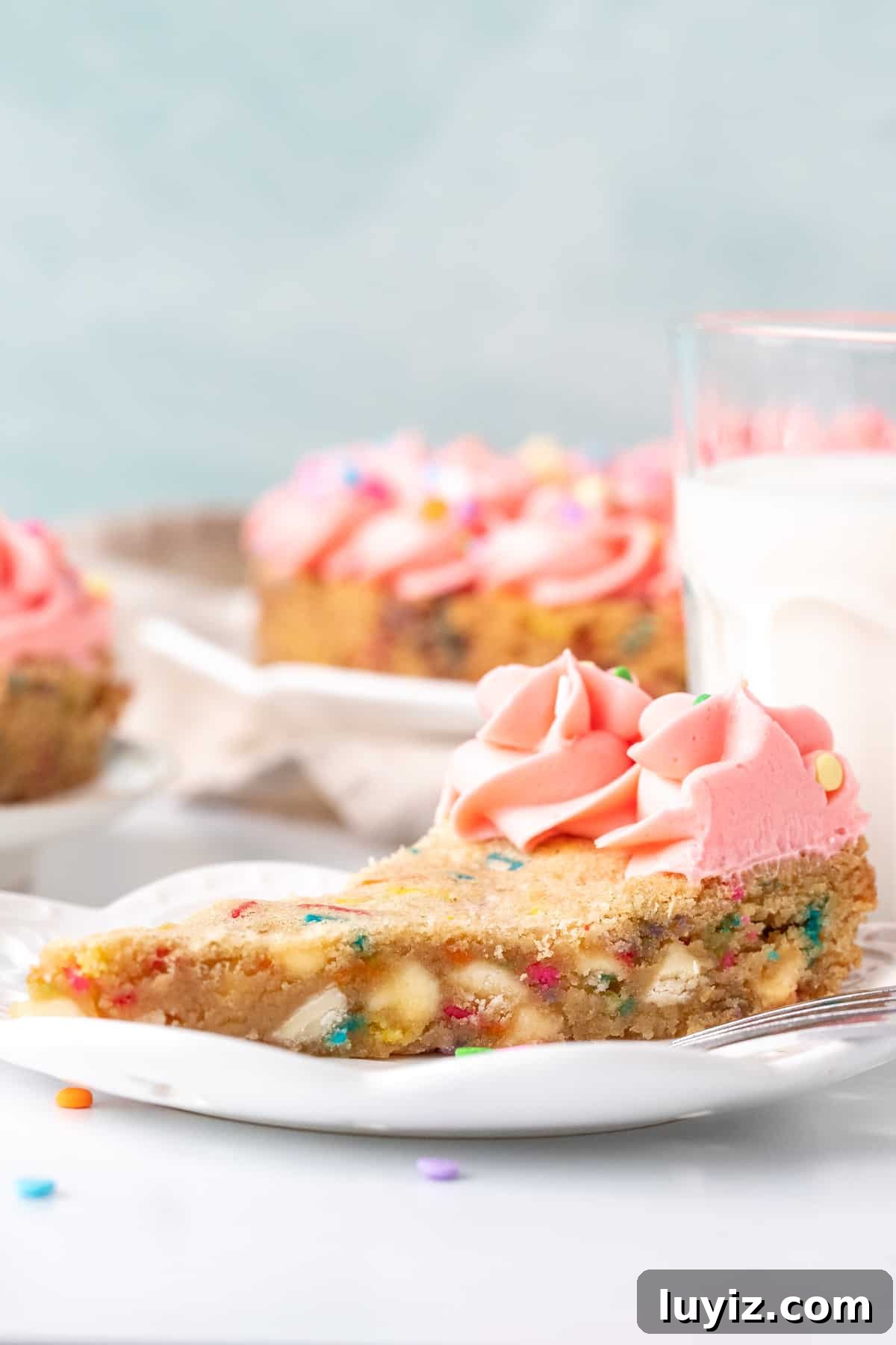 Funfetti Cookie Cake Recipe with Sprinkle-Filled Frosting 4 Slice of funfetti cookie cake with glass of milk