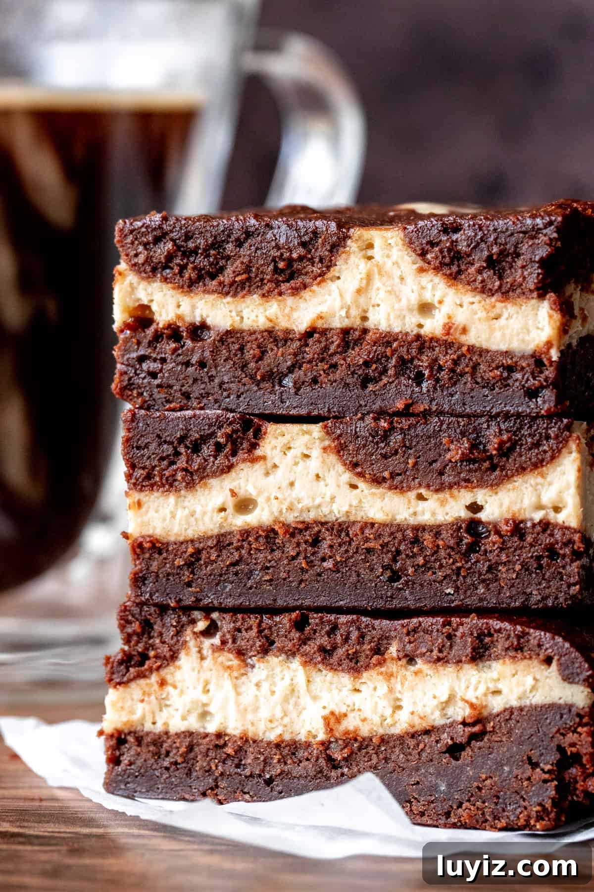Mocha Cheesecake Brownies Recipe — Rich Coffee Chocolate Swirls 2 Stack of 3 mocha cheesecake brownies with cup of coffee