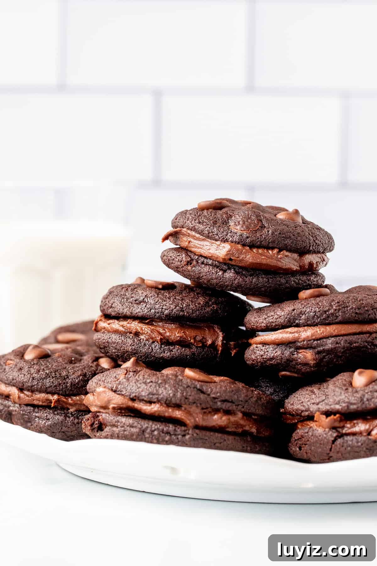 Double Chocolate Sandwich Cookies Recipe for Decadent Treats 4 Plate of chocolate sandwich cookies with chocolate frosting with glass of milk