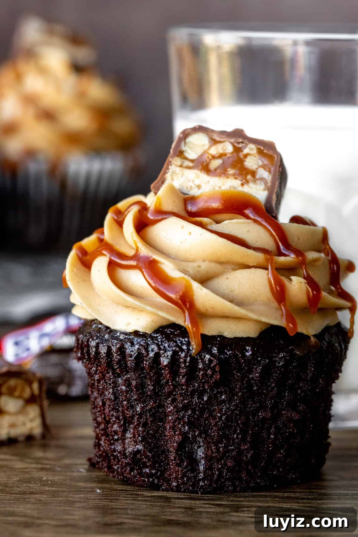 Decadent Snickers Cupcakes Recipe with Salted Caramel Drizzle 2 Snickers cupcakes with glass of milk