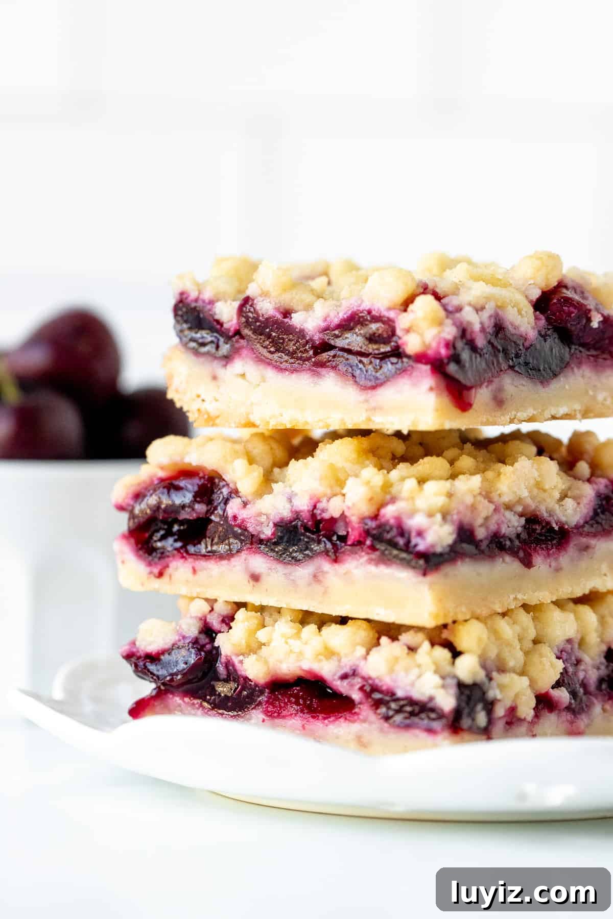 Chewy Cherry Crumb Bars Recipe with Golden Streusel 8 Three cherry shortbread bars with crumb topping, stacked one on top of eachother